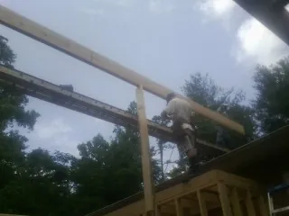 Carpenter setting a ridge beam over a new addition frame — Ice Dam Removal by Roofing Brothers in Campo