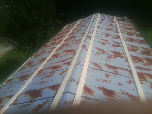 Rusted metal roof panels with new wood purlins before replacement — Storm Damage Roof Repair in Campo by Roofing Brothers